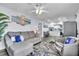 Comfortable living room with a sofa, chair, ceiling fan, and views to the modern, all-white kitchen at 758 Orchid Dr, Davenport, FL 33897