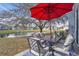 Outdoor patio featuring a table, chairs, red umbrella and a picturesque water view at 758 Orchid Dr, Davenport, FL 33897