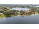 Aerial view of a lake with a fishing pier, tennis courts, and lush trees at 8128 Hook Cir, Orlando, FL 32836