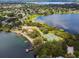 An aerial view of the lake with docks, tennis courts, sandy beach, and tree lined shore at 8128 Hook Cir, Orlando, FL 32836