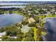 An aerial view of the lake with docks, tennis courts, a sandy beach and lush trees at 8128 Hook Cir, Orlando, FL 32836