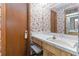 Bathroom with floral wallpaper, wooden cabinets, and marble sink at 8128 Hook Cir, Orlando, FL 32836