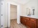 Elegant bathroom with wood-look flooring, white vanity, and walk-in closet at 8128 Hook Cir, Orlando, FL 32836