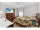 Cozy bedroom with a patterned quilt, chest of drawers, and natural light at 8128 Hook Cir, Orlando, FL 32836