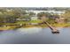 Scenic lake view with a wooden pier, tennis court, playground and lake vegetation at 8128 Hook Cir, Orlando, FL 32836