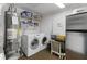 Functional laundry room with modern washer/dryer, storage shelves, and utility appliances at 8128 Hook Cir, Orlando, FL 32836