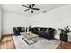 Living room with hardwood floors, a ceiling fan and three windows allowing in natural light at 8128 Hook Cir, Orlando, FL 32836