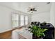 Living room with hardwood floors, a ceiling fan and three windows allowing in natural light at 8128 Hook Cir, Orlando, FL 32836