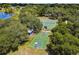 Aerial view of the community tennis and basketball courts surrounded by mature trees and lake at 8128 Hook Cir, Orlando, FL 32836