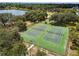 Aerial view of tennis courts surrounded by lush trees near the lake at 8128 Hook Cir, Orlando, FL 32836