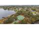 Aerial view of a lakefront community with tennis courts, playground, and mature trees at 8128 Hook Cir, Orlando, FL 32836