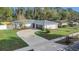 Aerial view of a charming home featuring fresh landscaping, an inviting driveway, and a gray roof at 8691 Contoura Dr, Orlando, FL 32810