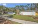 Lush front yard features manicured greenery and a brick-edged flowerbed, adding charm to the home's exterior at 8691 Contoura Dr, Orlando, FL 32810