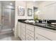 Bathroom featuring double sinks, a shower with glass door, and neutral toned tile at 8912 Adriatico Ln, Kissimmee, FL 34747