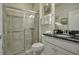 Bathroom featuring a single vanity with a dark countertop, a shower with glass door, and neutral toned tile at 8912 Adriatico Ln, Kissimmee, FL 34747