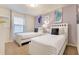 Bedroom featuring two beds with white headboards, a nightstand, and a window with blinds at 8912 Adriatico Ln, Kissimmee, FL 34747