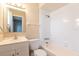 Bright, all-white bathroom with a shower-tub combo and large mirror at 97 Lake Villa Way, Kissimmee, FL 34743