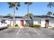 Condo exterior view with palm trees, street parking and brightly colored doors at 97 Lake Villa Way, Kissimmee, FL 34743