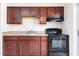 Well-lit kitchen with dark wood cabinets, laminate countertops, and black appliances at 97 Lake Villa Way, Kissimmee, FL 34743