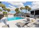 Community pool with lounge chairs and tables surrounded by palm trees at 97 Lake Villa Way, Kissimmee, FL 34743