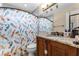 This bathroom features a granite countertop, a dark wood cabinet, and a colorful mermaid-themed shower curtain at 1006 Gotwalt Dr, Oviedo, FL 32765