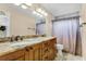 Spacious bathroom featuring dual sinks with a granite countertop and a large mirror with decorative lighting at 1006 Gotwalt Dr, Oviedo, FL 32765
