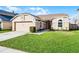Well-kept one-story home with an attached two-car garage, lush green lawn, and tidy landscaping at 1006 Gotwalt Dr, Oviedo, FL 32765