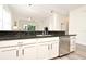 A kitchen featuring a stainless steel dishwasher, dark countertop and white cabinets at 1071 Kersfield Cir, Lake Mary, FL 32746