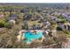 Aerial view of a community pool area with sun loungers, palm trees, and a clubhouse nestled among homes and mature trees at 1098 Victoria Hills S Dr, Deland, FL 32724