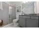 This full bathroom features a tiled frameless shower and a granite countertop sink at 1121 Avery Meadows Way, Deland, FL 32724