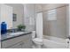 This full bathroom features a shower-tub combo and a granite countertop sink at 1121 Avery Meadows Way, Deland, FL 32724