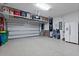 Spacious garage with epoxy floors, overhead storage racks, white refrigerator, and ample space for vehicles at 1121 Avery Meadows Way, Deland, FL 32724