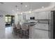 Modern kitchen featuring white cabinets, stainless steel appliances, granite countertops, and bar seating at 1121 Avery Meadows Way, Deland, FL 32724
