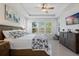 This primary bedroom offers tile floors, a trey ceiling with fan, and a large window with shutters for natural light at 1121 Avery Meadows Way, Deland, FL 32724