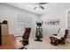Bright office space offering a tile floor, a ceiling fan, a desk with a brown leather chair, and an elliptical machine at 1121 Avery Meadows Way, Deland, FL 32724