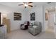 This additional living space offers two chairs, modern artwork and a ceiling fan at 1121 Avery Meadows Way, Deland, FL 32724