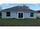 Backyard featuring a gray exterior and sliding glass doors at 117 Stewart Lake Loop, Groveland, FL 34736