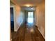 Inviting hallway with wood-look floors, leading to a bright and airy living space with sliding glass doors at 117 Stewart Lake Loop, Groveland, FL 34736