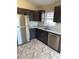 Modern kitchen equipped with stainless steel appliances, granite countertops, and stylish dark wood cabinetry at 117 Stewart Lake Loop, Groveland, FL 34736