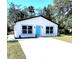 Charming single-story home featuring a modern design with a bright blue front door at 1200 Jarecki Ave, Holly Hill, FL 32117