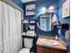 Cozy bathroom featuring blue walls, decorative mirror, and classic sink at 1207 Rich Moor Cir, Orlando, FL 32807