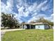Inviting single-story home with a unique covered entryway and lush front lawn under a bright, partly cloudy sky at 1207 Rich Moor Cir, Orlando, FL 32807