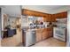 Well-lit kitchen featuring wood cabinets, stainless steel appliances, and an adjacent dining area at 1207 Rich Moor Cir, Orlando, FL 32807