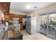 Bright kitchen with wooden cabinets, tile floor, stainless steel refrigerator, and access to a backyard patio at 1207 Rich Moor Cir, Orlando, FL 32807