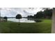 Expansive backyard featuring a tranquil pond and lush green lawn at 12126 Homestead Park Ln, Orlando, FL 32824