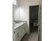 Bathroom with double vanity, granite countertops, and view to Primary bedroom with a luxurious king bed at 12126 Homestead Park Ln, Orlando, FL 32824
