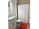 A clean bathroom showcasing a white vanity with granite countertops, a toilet, and a shower with a white curtain at 12126 Homestead Park Ln, Orlando, FL 32824