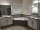 Bathroom featuring a garden tub, granite countertops, double sinks, and stylish fixtures at 12126 Homestead Park Ln, Orlando, FL 32824
