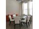 Bright dining room with white chairs, glass table, orange cabinet, and modern lighting at 12126 Homestead Park Ln, Orlando, FL 32824