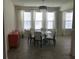 The bright dining room features white chairs and a glass table lit by a modern chandelier at 12126 Homestead Park Ln, Orlando, FL 32824